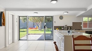 A modern kitchen with a sliding glass door leading to a backyard. - The Anchorage - 1 Marjory Street (Normanville)