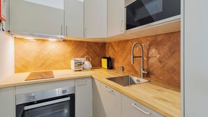 A modern kitchen with a herringbone-patterned backsplash, stainless steel appliances, and a wooden countertop. - Setúbal Downtown Fonte Nova, By Home Match (Setúbal)