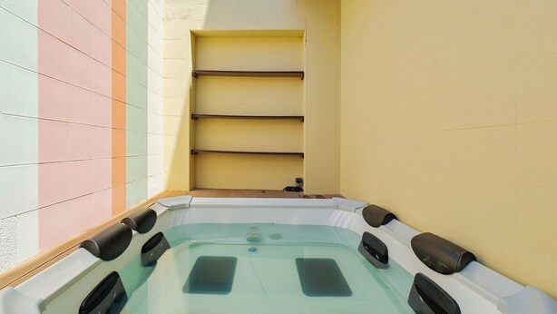 A hot tub in a corner with tiled walls and a shelf above. - Setúbal Downtown Fonte Nova, By Home Match (Set úbal)