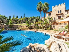A pool area with a stone building, palm trees, and lounge chairs. - Luxus Ferienvilla Finca for Holiday Spa Retreat by Interhome (Son Servera)