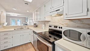 A modern kitchen with white cabinets, a stainless steel range, an oven, a microwave, and a dishwasher. - Spacious 2BR/2.5BA Beach Getaway | Relax & Unwind (North Myrtle Beach)