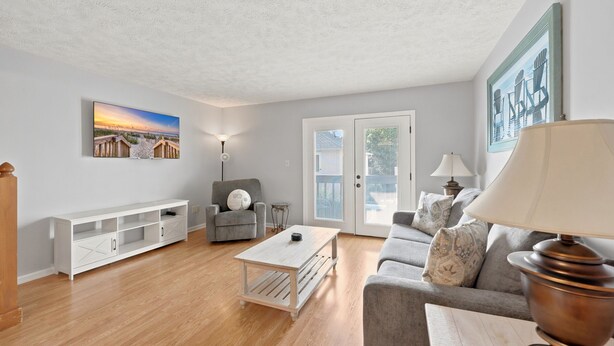 A living room with a white entertainment unit, a grey sofa, a coffee table, and a lamp. - Spacious 2BR/2.5BA Beach Getaway | Relax & Unwind (North Myrtle Beach)