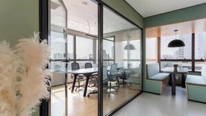 A modern office space with glass walls, a conference table, and seating areas. - Nik Perdizes: Premium Studio 400m from Nubank Parque (formerly Allianz Parque) (São Paulo)