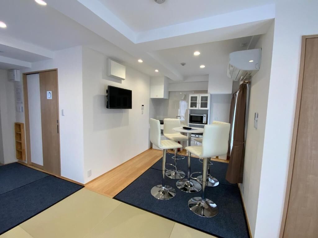 A modern kitchen with white cabinets, a built-in oven, and a microwave.