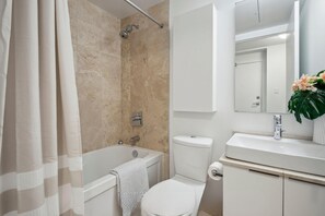 Een badkamer met een bad, toilet en wastafel.