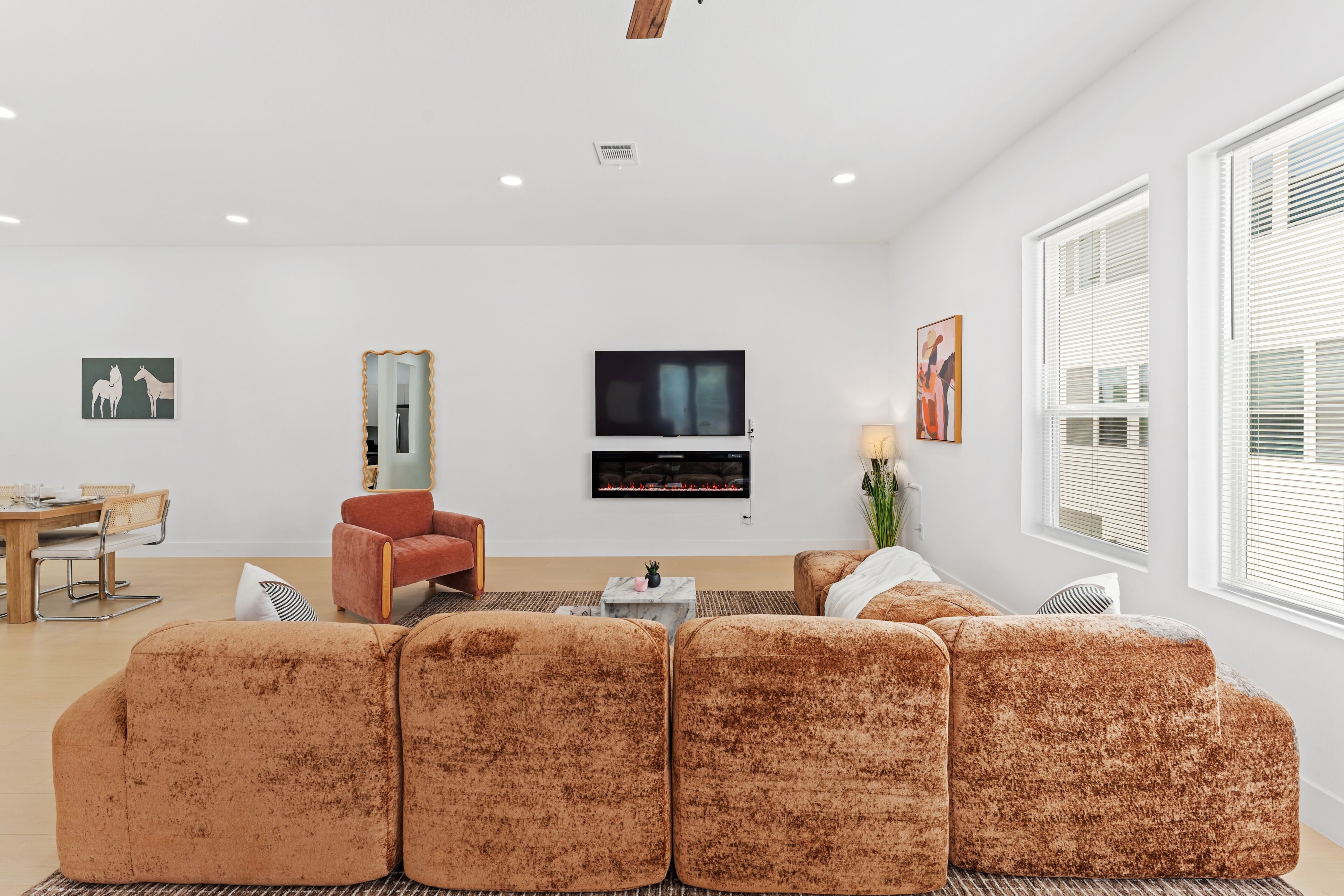 A modern living room with a sofa, a TV, and artwork on the walls.