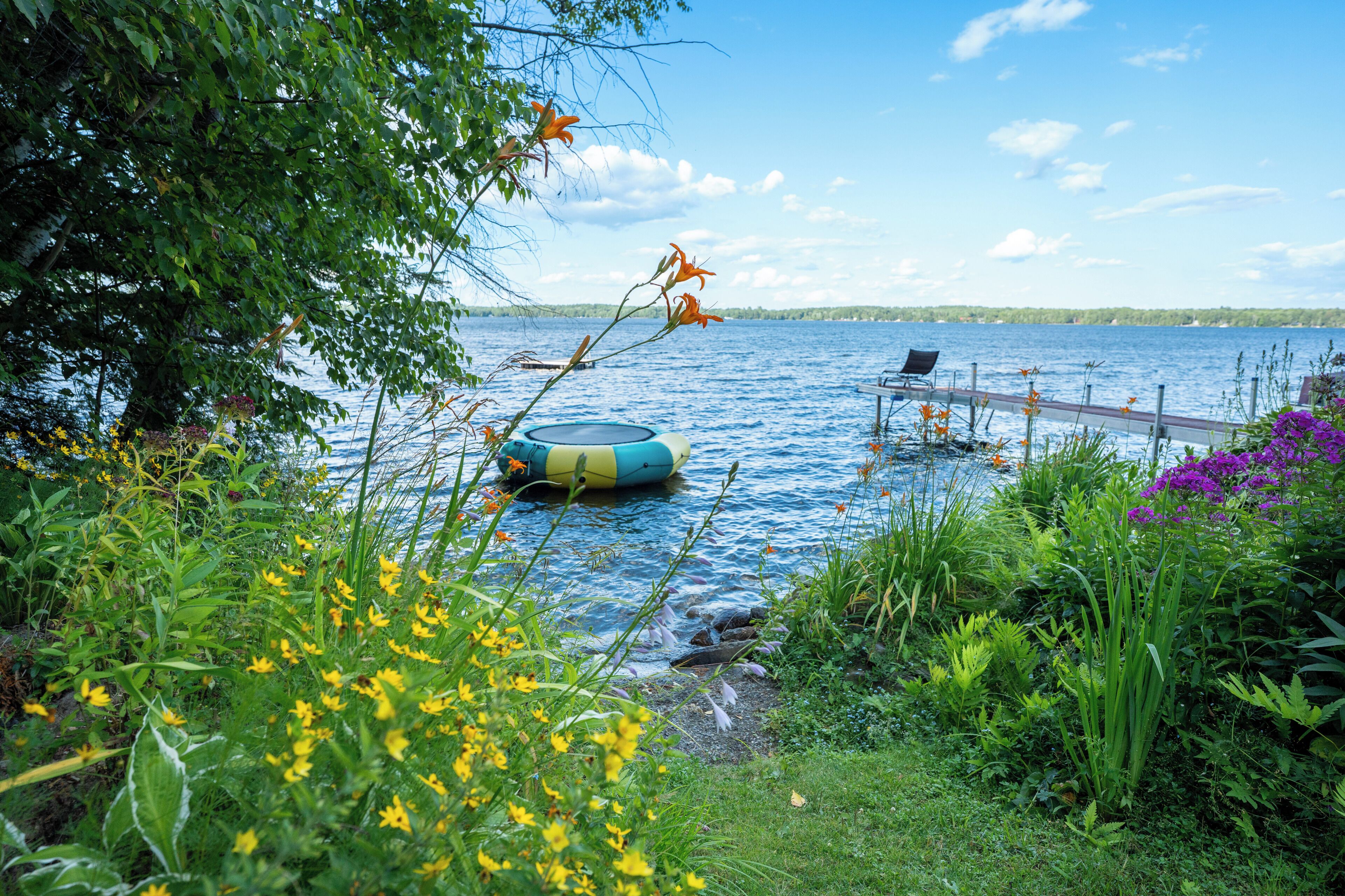 Une vue sur le lac, avec un quai flottant et un bateau.
