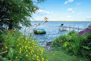 Vista de un lago con un muelle flotante y un bote.