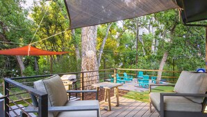 Una terrazza con mobili da esterno, un barbecue e un albero.