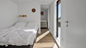 A bedroom with a bed, a small bedside table, a clock, and a window. - Awesome home in Munkebo with house sea view (Munkebo)