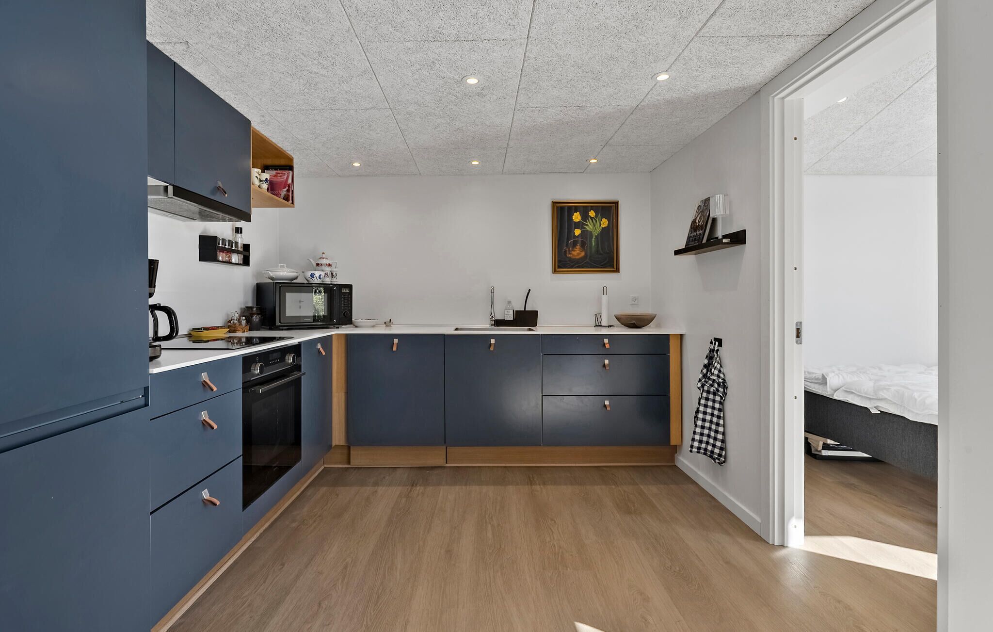 A compact kitchen with a microwave, stove, and cabinets.