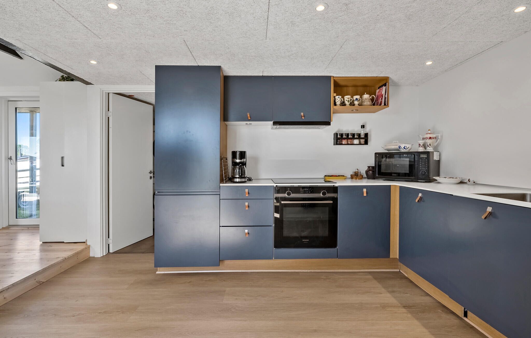 A modern kitchen with built-in appliances, a coffee maker, and a microwave.
