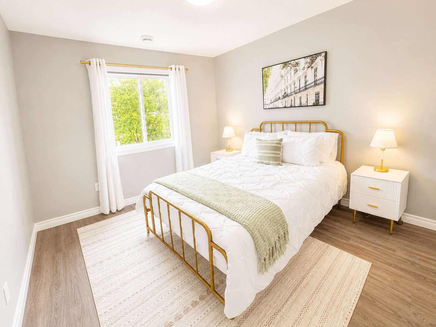 Quarto com cama, mesas de cabeceira, janela com cortinas, quadro na parede e tapete estampado.