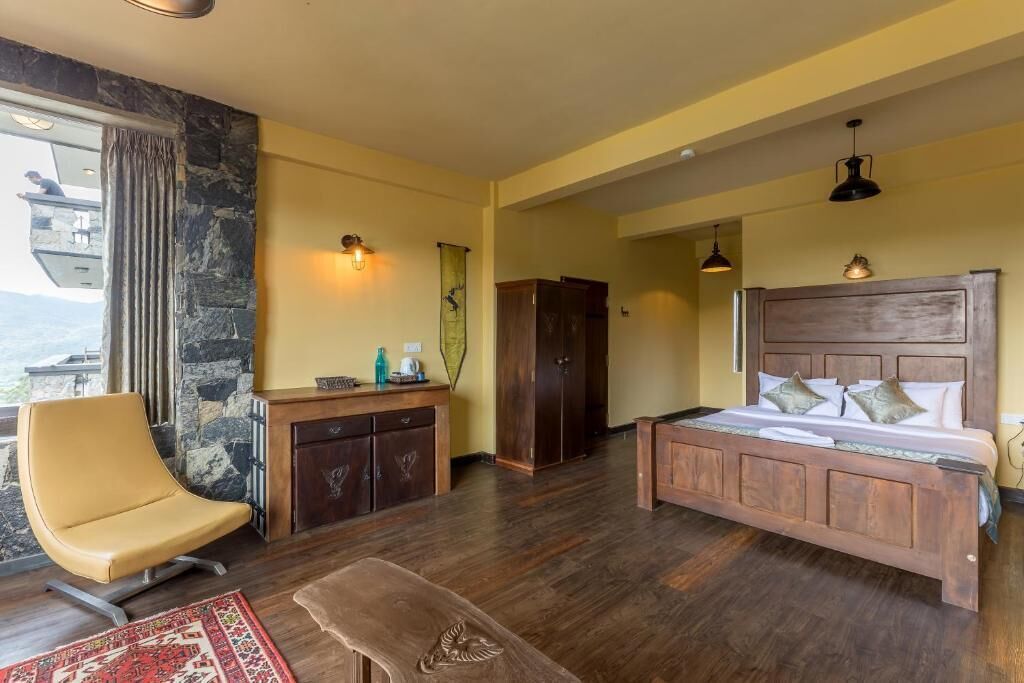 A bedroom with a bed, a chair, a desk, and a wardrobe.
