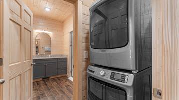 A compact kitchen with a built-in oven and microwave, wooden walls, and a small countertop.