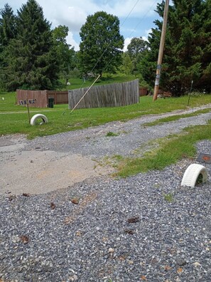 A gravel road with a wooden fence, a wooden post with a sign, and a grassy field with trees in the background. - Private 1-BR Ensuite with Separate Entrance I 5min DT Jonesborough (Jonesborough)