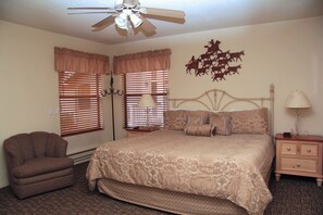 A bedroom with a bed, a chair, a nightstand, a lamp, and a ceiling fan. - Enjoyable 2-bedroom townhome with AC in Pinetop Country Club (Pinetop Country Club)