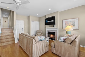 A living room with a fireplace, a television, a sofa, and a lamp. - Family-Friendly 3BR/2BA OCNJ Getaway with Parking, Patios & Outdoor Shower (Ocean City)