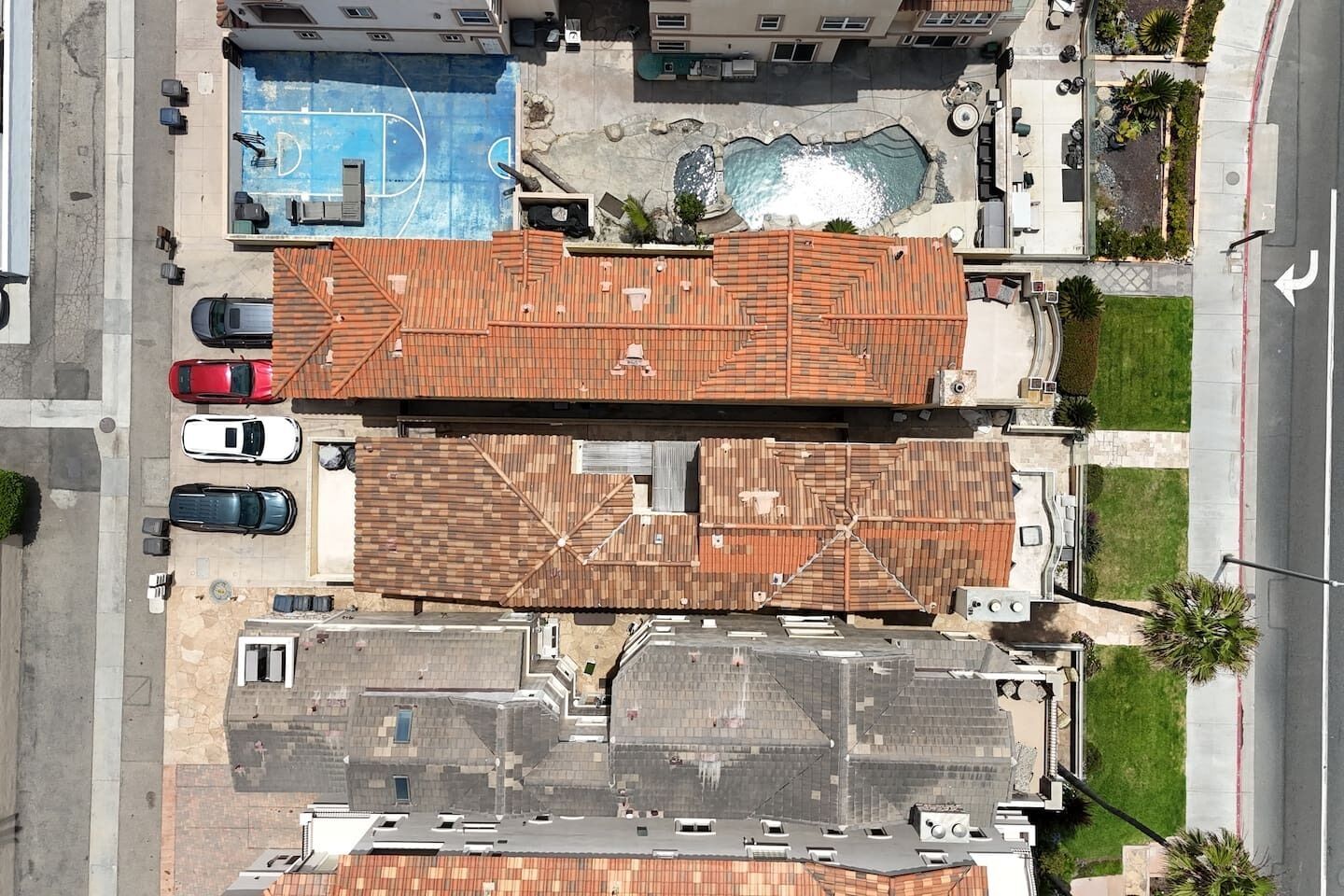 A residential area with multiple buildings, a swimming pool, and a tennis court.