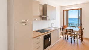 Eine moderne Küche mit Einbauofen, Spüle und Essbereich mit Tisch und Stühlen.