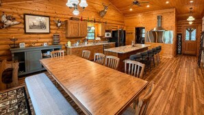 L’intérieur d’un chalet en bois comprend un coin repas, une cuisine et une grande fenêtre.