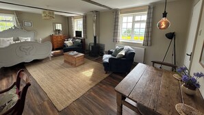 Ein gemütliches Zimmer mit Bett, Sofa, Couchtisch aus Holz und Kamin.