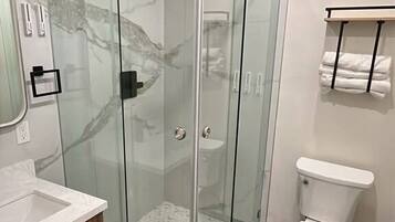 Een douche, handdoeken, zeep, shampoo