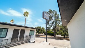 A hotel sign with 'Nox Hotel' written on it, a building with a white facade and a black roof, and a palm tree in the background. - Nox Hotel - Studio City (Studio City)