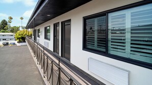 A building with a covered walkway, large windows, and a parking lot. - Nox Hotel - Studio City (Studio City)