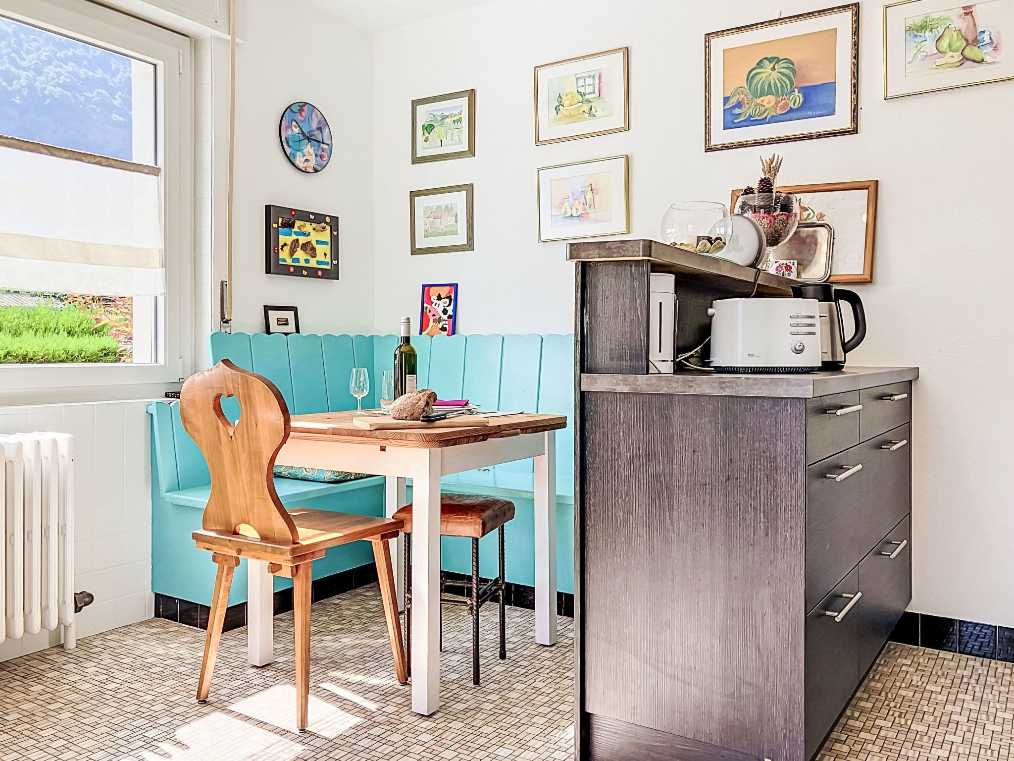 Une cuisine équipée d’une table à manger, de chaises, d’un four à micro-ondes et d’un meuble de rangement.