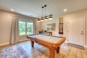 A pool table in a room with a large window, a door, and a ceiling light fixture. - Beautiful lake side retreat in the Blue Ridge Mountains of north Georgia. (Blairsville)