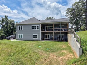 A two-story house with a balcony, a driveway, and a grassy yard. - Beautiful lake side retreat in the Blue Ridge Mountains of north Georgia. (Blairsville)