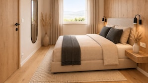 A bedroom with a bed, a window with curtains, a bedside table, and a wall-mounted lamp. - Modern vacation home near the gondolas (Kirchberg in Tirol)