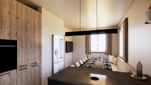 A modern kitchen with a central island, built-in appliances, and a dining area with a sofa. - Modern vacation home near the gondolas (Kirchberg in Tirol)