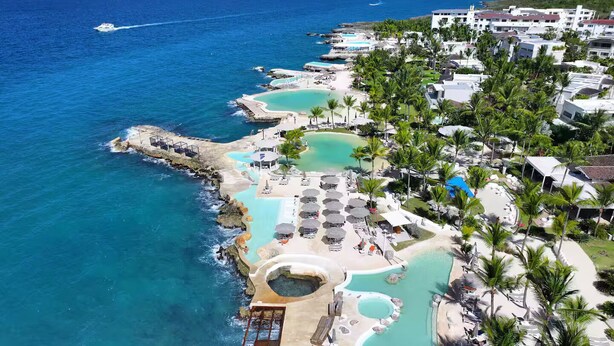 Ein Küstenresort mit mehreren Schwimmbecken, einem Strandbereich und Blick auf den Ozean.