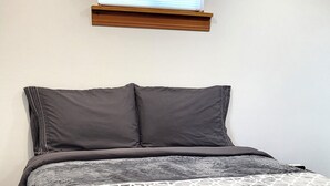 Una cama con un edredón estampado, dos almohadas y un cabecero de madera.