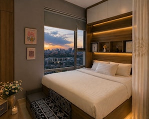 Quarto moderno com uma cama grande, vista para a cidade e cabeceira de madeira.