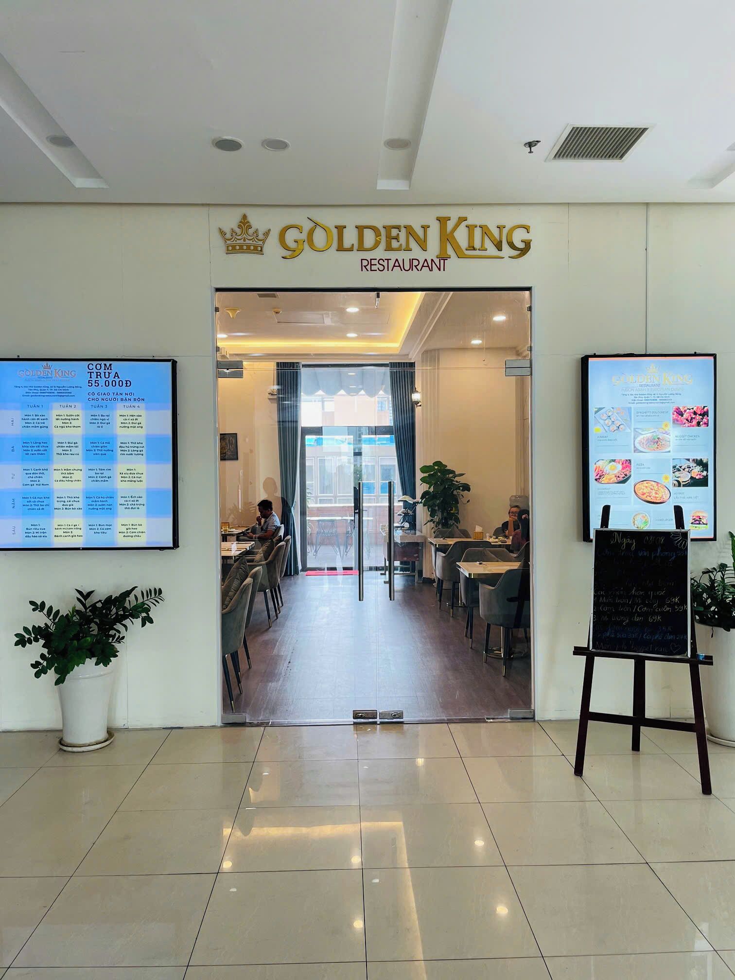 L’entrée du restaurant Golden King, avec un panneau affichant le menu à gauche et un tableau noir présentant les plats du jour à droite.