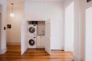 A compact laundry room with a washing machine, a dryer, and a sink.