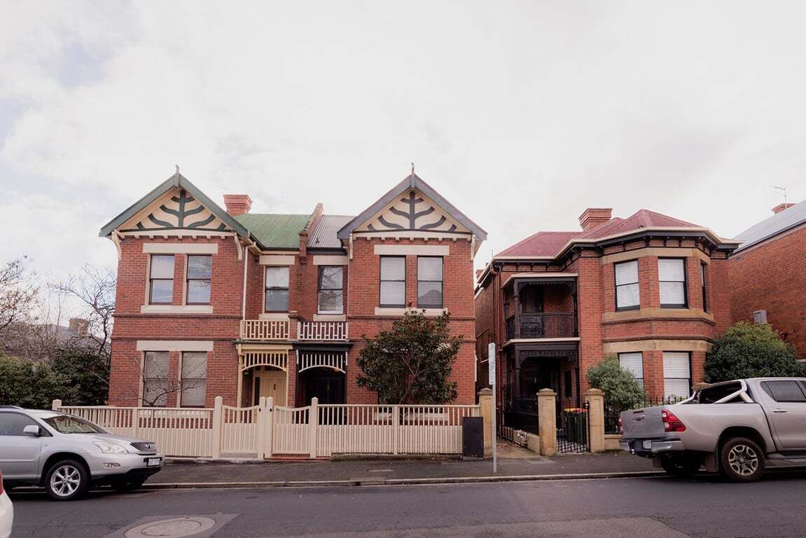 Un bâtiment de style victorien, doté d’un porche avant imposant, d’un balcon et d’une façade en briques.