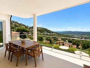 A balcony with a wooden table and chairs, offering a view of a hilly landscape. - Villa Belleza - Santa Cristina d'Aro, Catalonia (Santa Cristina d'Aro)