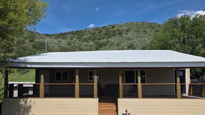 A single-story building with a flat roof, a covered porch, and a small staircase leading to the entrance.