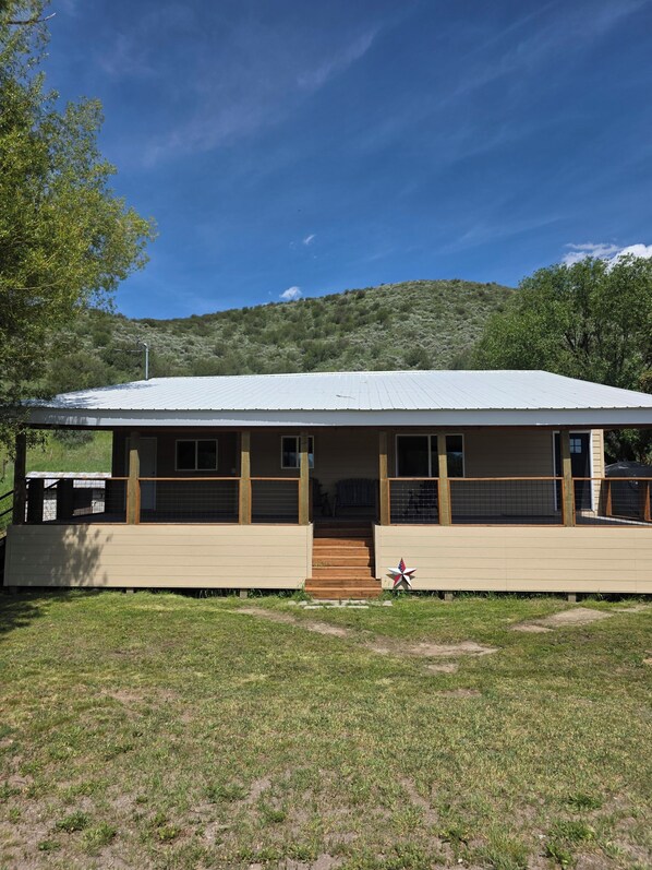 A single-story building with a flat roof, a covered porch, and a small staircase leading to the entrance.