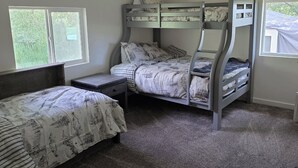 A bedroom with bunk beds, a window, and a carpeted floor.