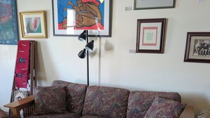 A living room with a patterned sofa, a wooden coffee table, and a rug. - The Mini Place, Buffalo (Buffalo)