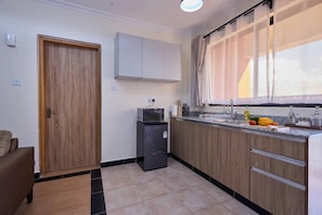 Departamento ejecutivo, 1 habitación | Cocina privada | Refrigerador, microondas, horno y parrilla de estufa 