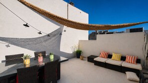 An outdoor patio with a dining table, chairs, a sofa set, and potted plants. - In the heart of the harbor with a rooftop view of the ocean (La Ciotat)