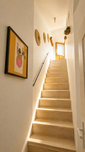 A staircase with a handrail, a framed picture on the wall, and a door at the top. - In the heart of the harbor with a rooftop view of the ocean (La Ciotat)
