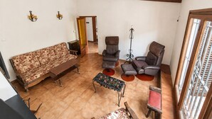 A spacious living room with a sofa, two armchairs, a coffee table, and a tall floor lamp.
