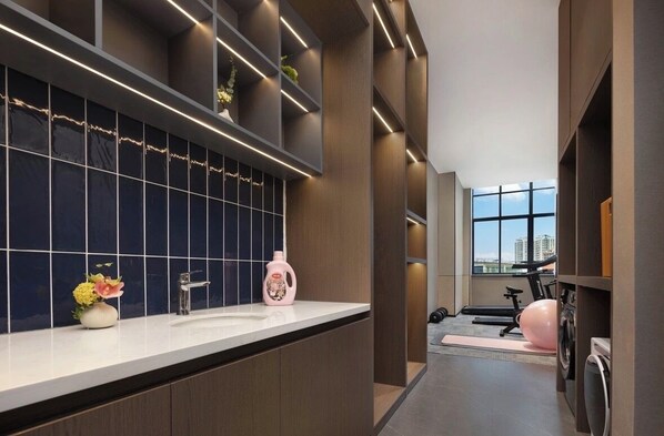 A modern bathroom with a large mirror, a sink, and a shower area.